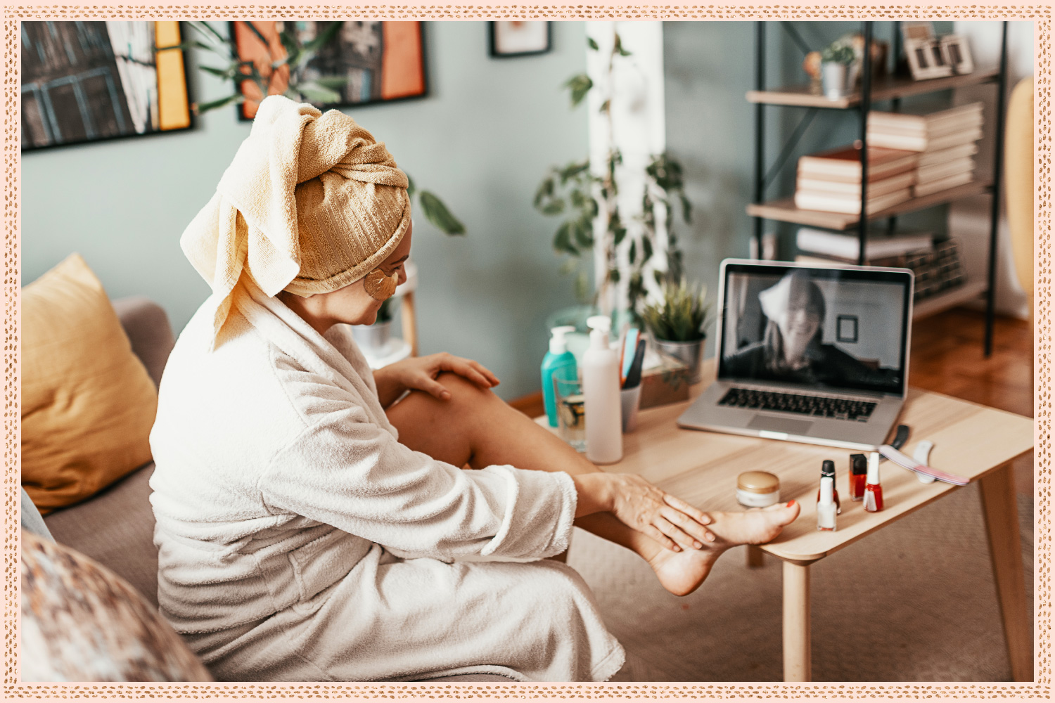 woman with towel on head and face mask on video chatting her friend on her laptop