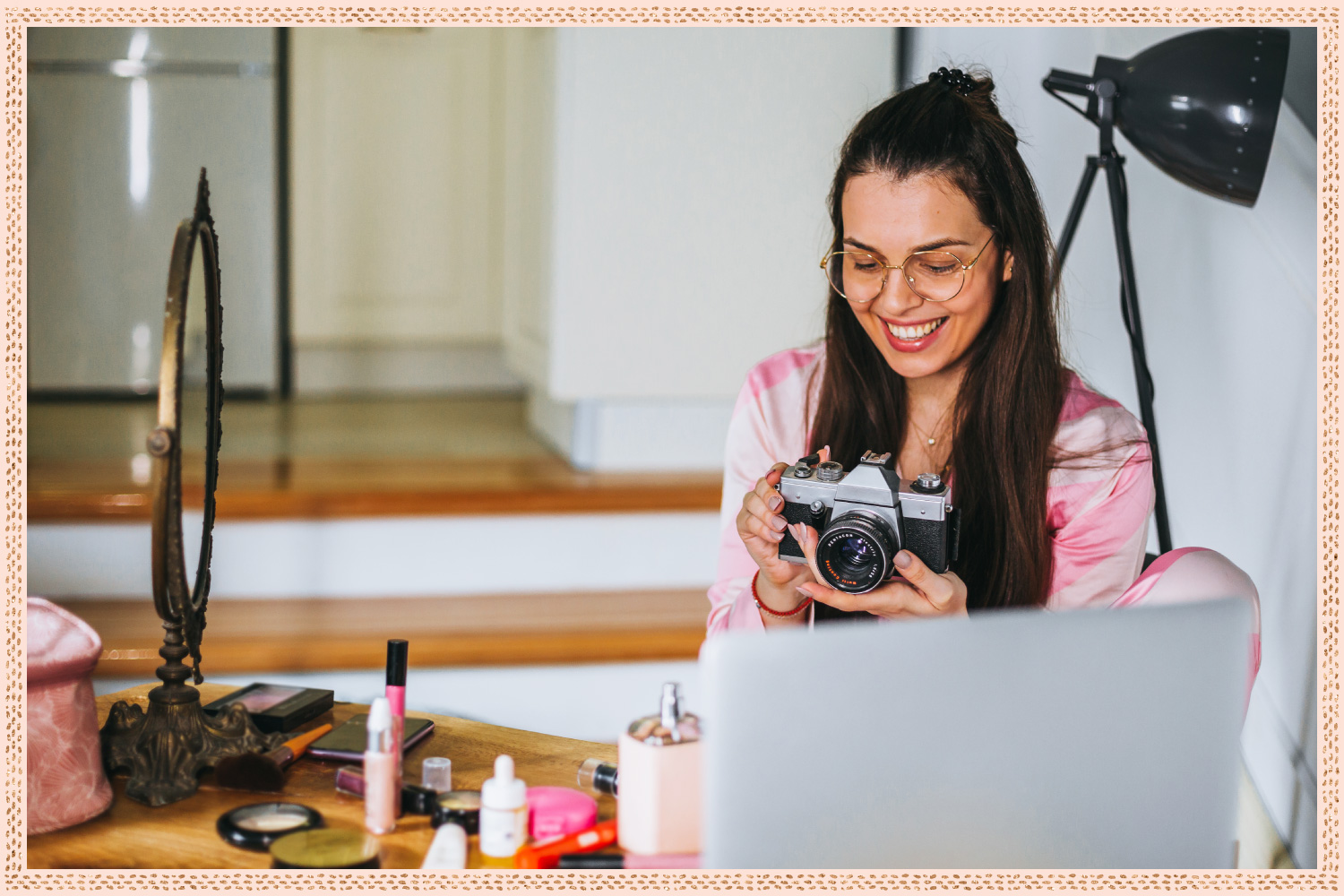 woman smiling at camera in front of vanity with laptop on