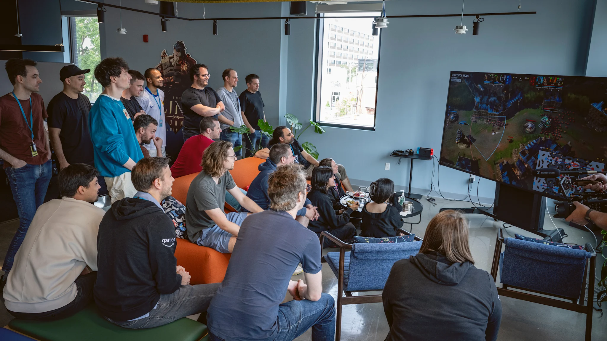 A group of creators sit around a large TV watching March of Giants gameplay