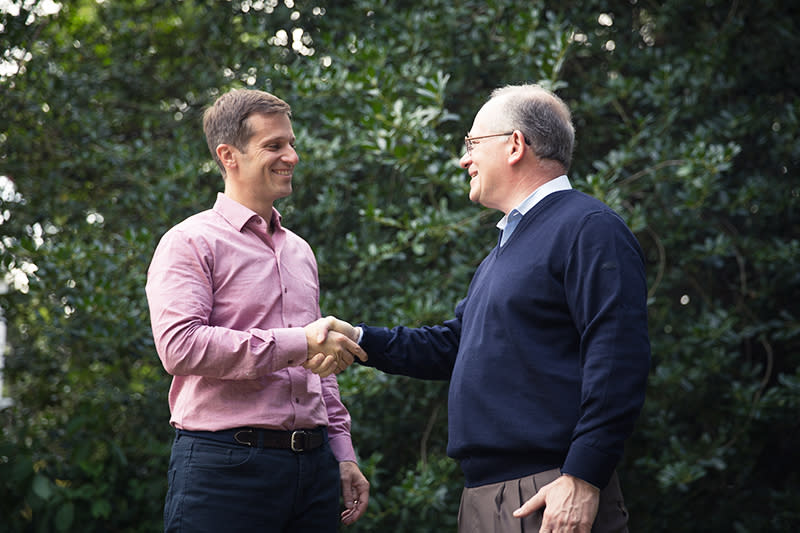 Mark Baiada and David Baiada shaking hands