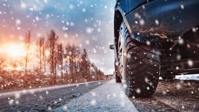 Car tires on winter road covered with snow
