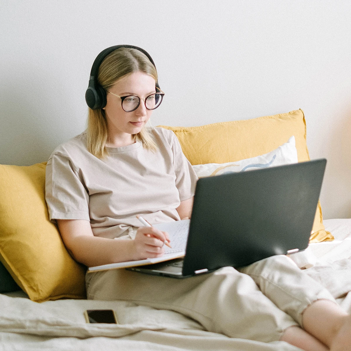 Photo of Woman Sitting on Bed While Using Black Laptop