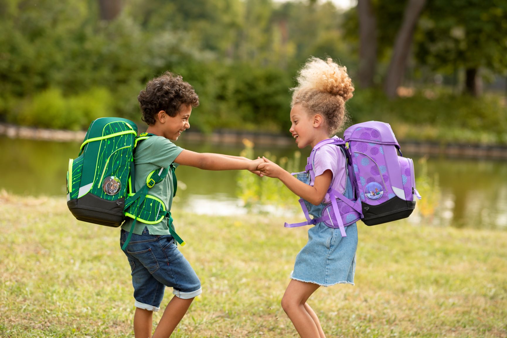 Ergobag Outdoor Junge und Mädchen toben auf Wiese 