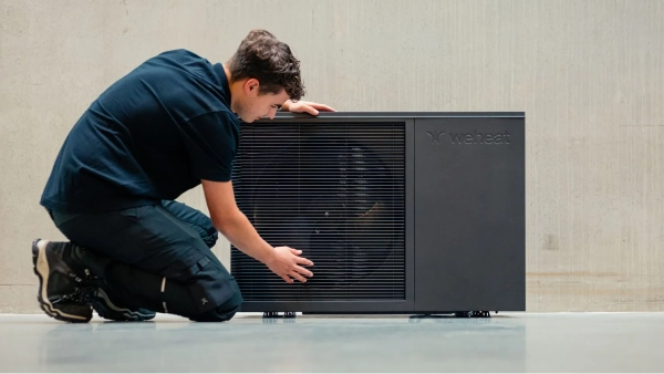 WeHeat Flint monoblock buitenunit tegen gevel installateur controleert de buitenunit