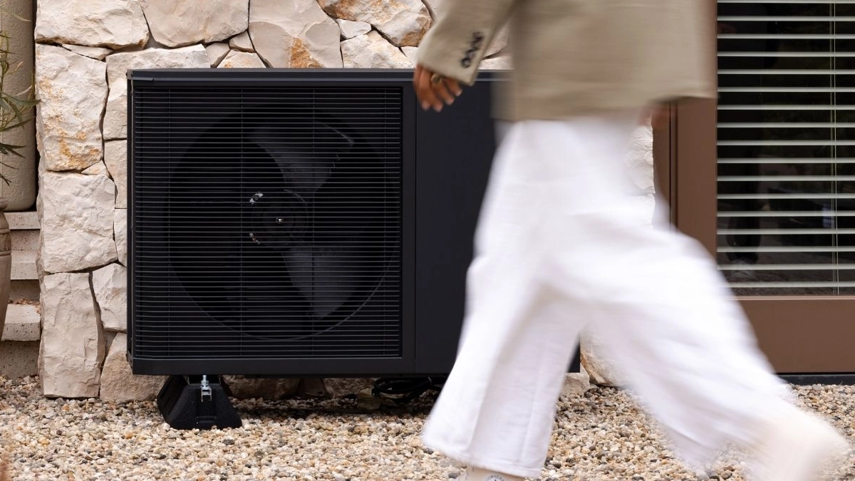 WeHeat Flint monoblock buitenunit tegen gevel aan persoon loopt er voor langs