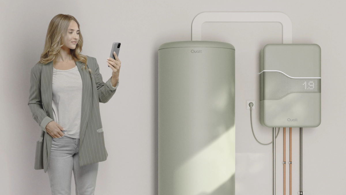 Quatt 14kw monoblock all electric vrouw staat bij boilervat op haar telefoon te kijken