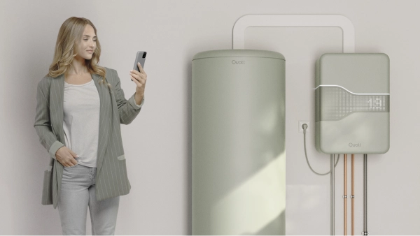 Quatt 14kw monoblock all electric vrouw staat bij boilervat op haar telefoon te kijken