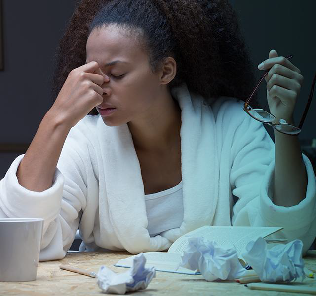 Tired woman touching her nose.