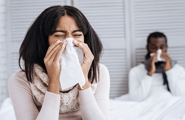 Woman and man blowing nose
