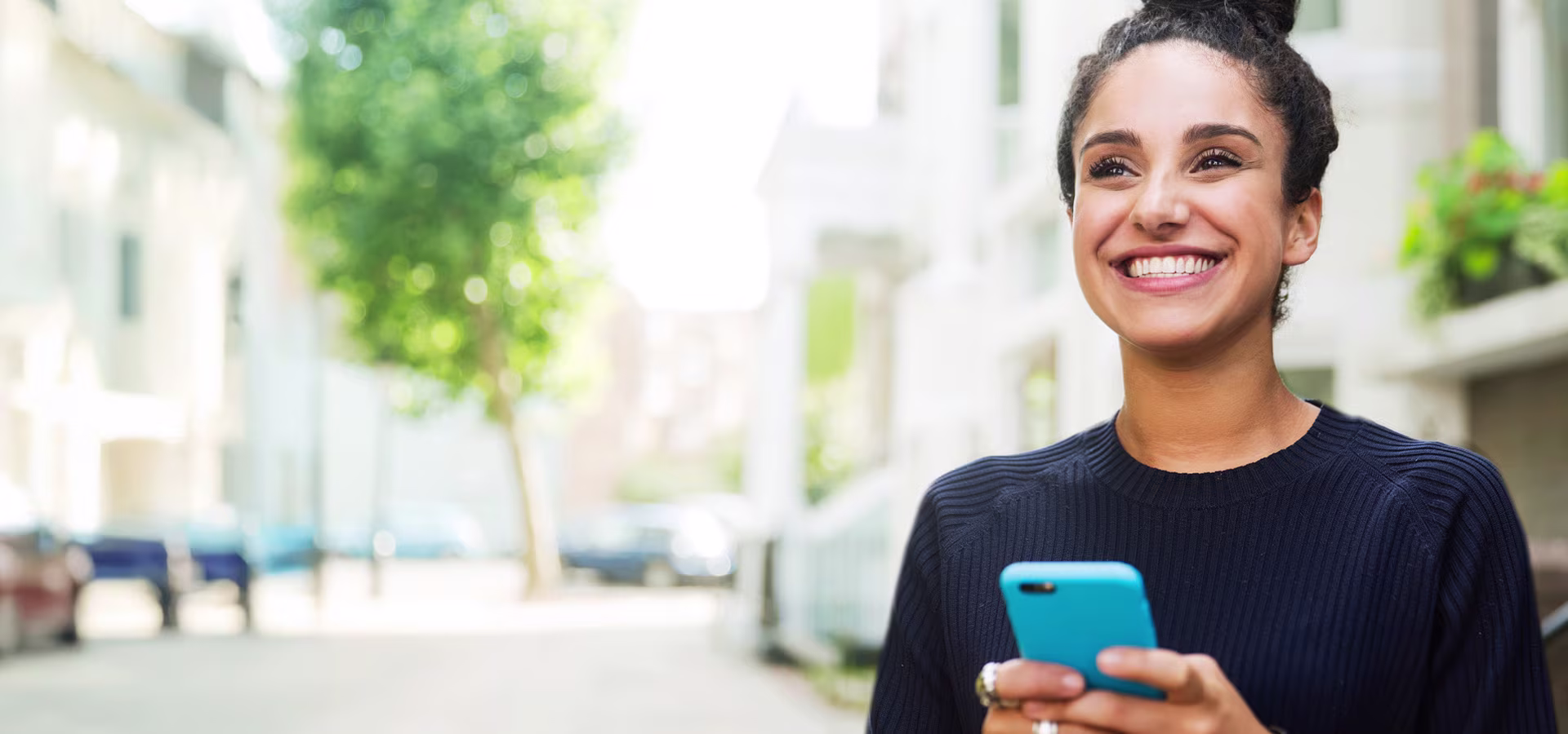 woman-smiling-with-phone-in-hand