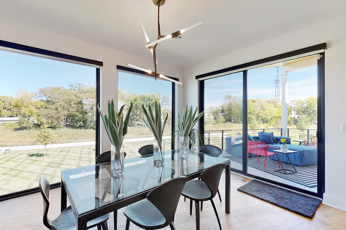 HDR photo of dining room with modern light fixture and large windows