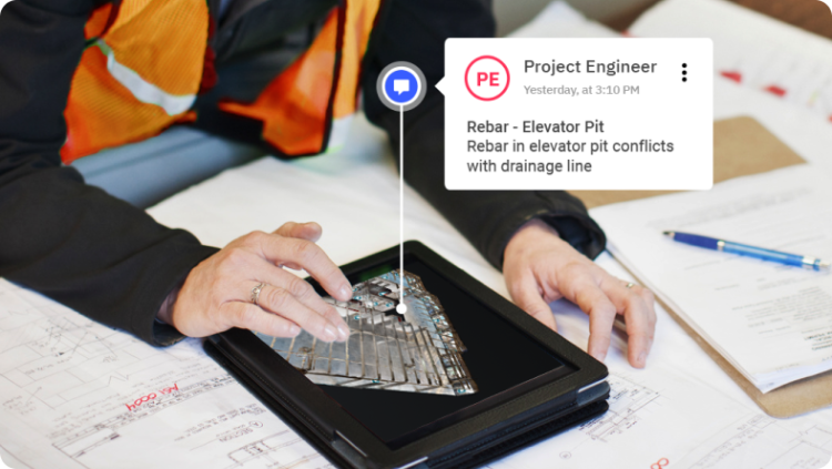 A construction worker working on a tablet showing a Matterport Model - with a note popped out for the Project Engineer