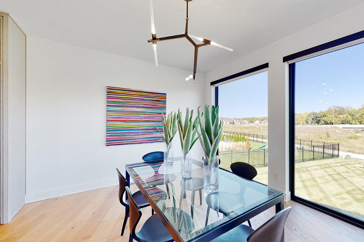 HDR photo of dining room with modern light fixture and large windows