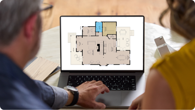 A man and a woman looking at a color floor plan image on a laptop