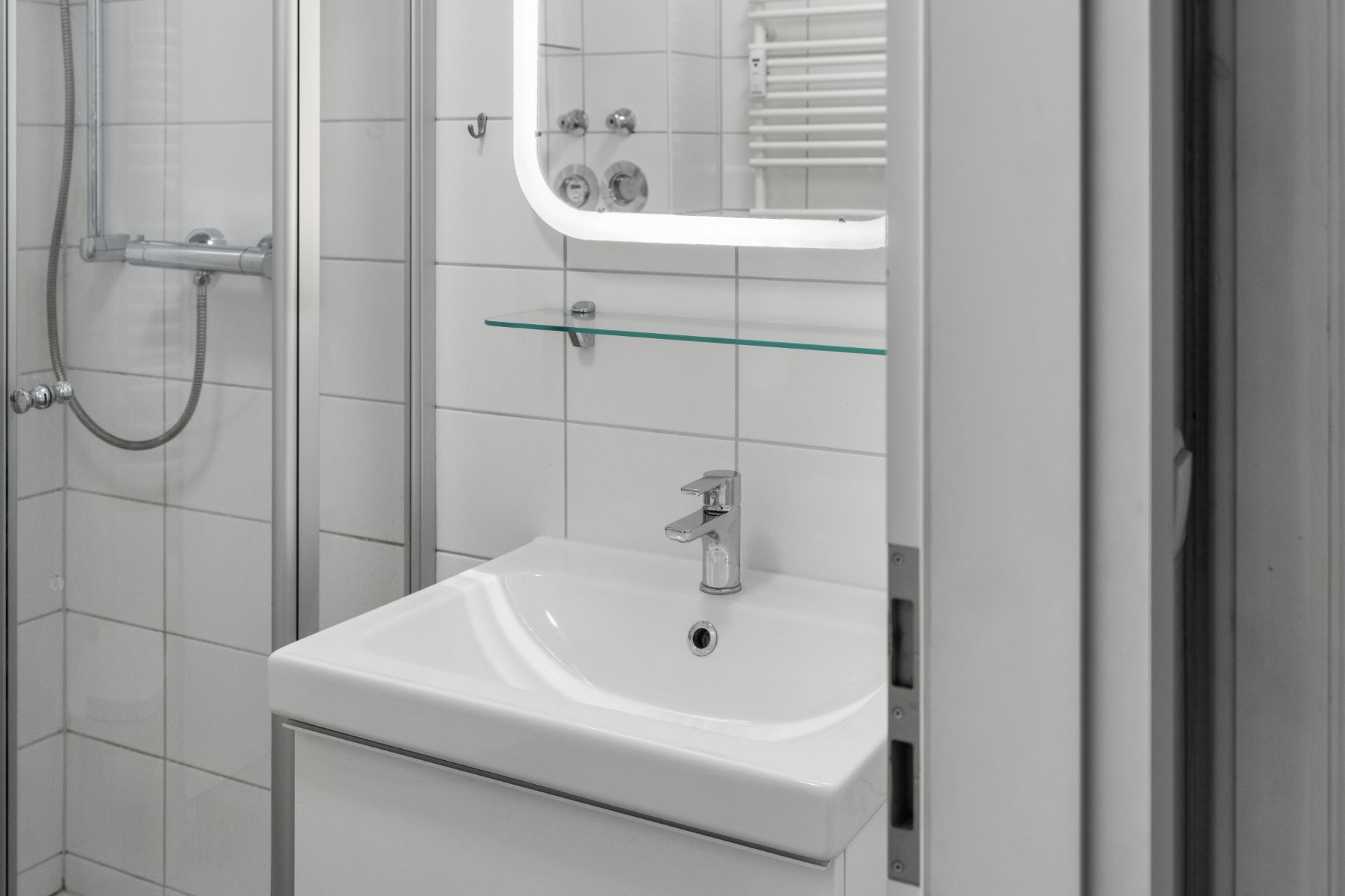 Modernes Badezimmer mit Waschbecken, Spiegel und Dusche.