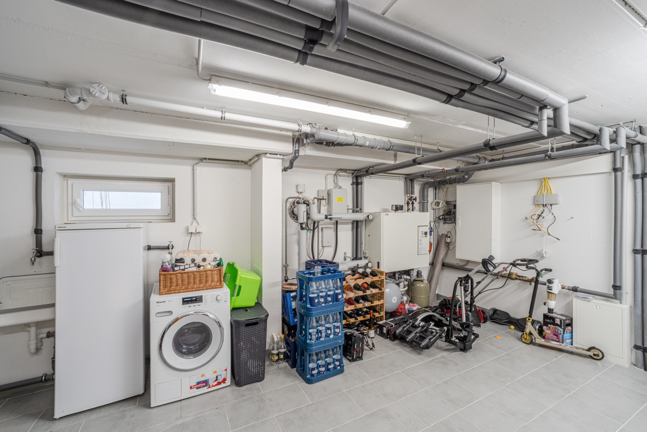 Kellerraum mit Waschmaschine, Gefrierschrank, Getränkekisten, Weinregal und einigen Werkzeugen.