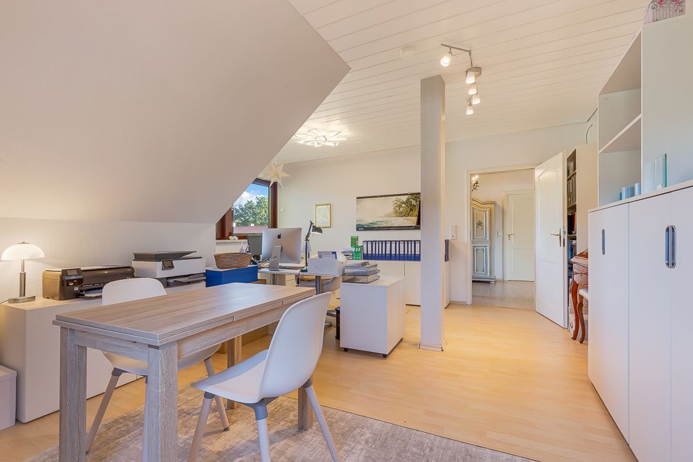 Helles Arbeitszimmer mit Schreibtischen, Stühlen, Regalen und Fenstern, moderne Einrichtung.