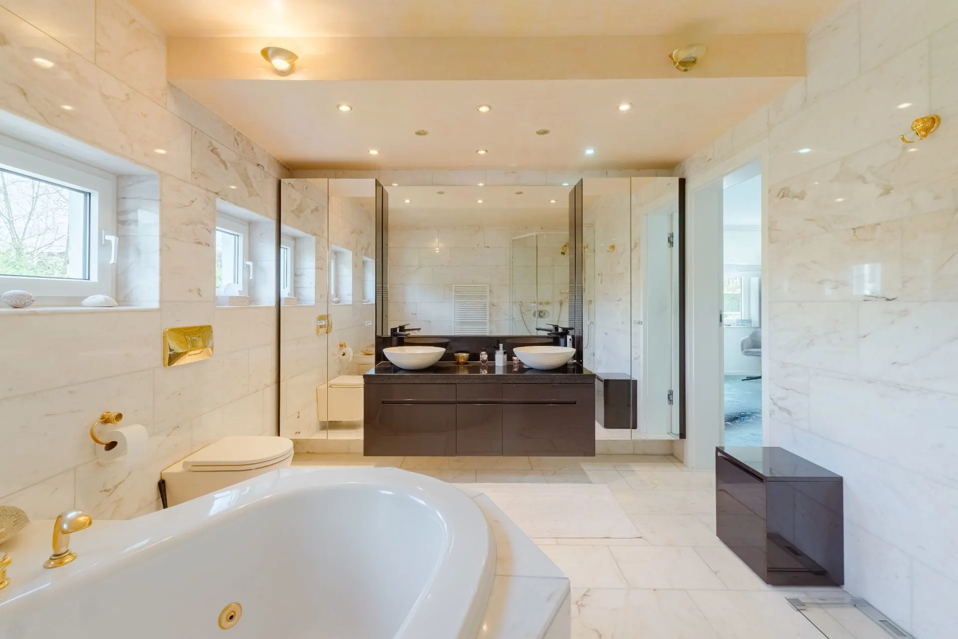 Modernes Badezimmer mit freistehender Badewanne, Doppelwaschtisch und großen Spiegeln.
