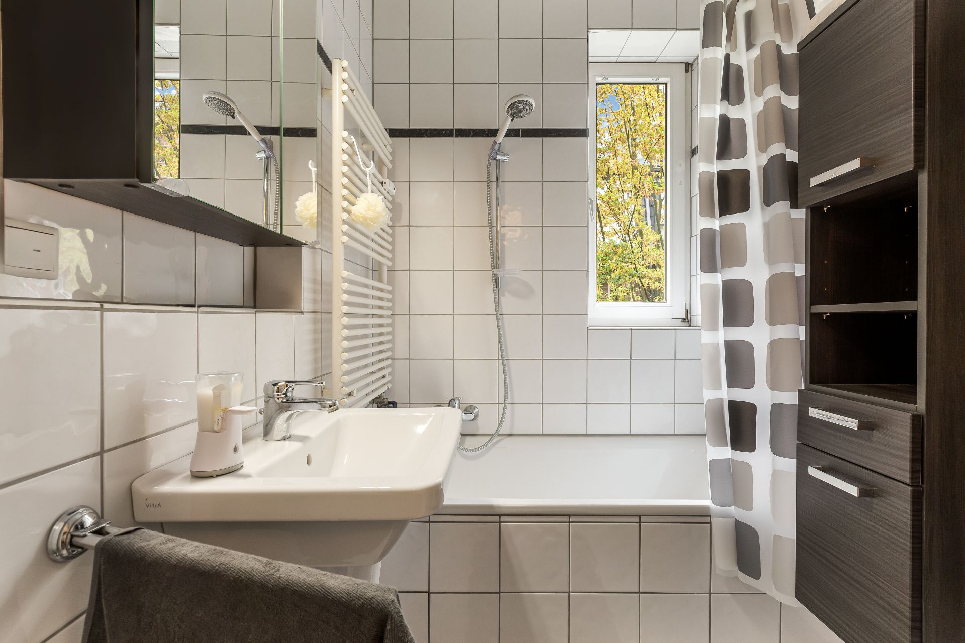Modernes Badezimmer mit Badewanne, Waschbecken, Spiegel, Regalen und Fenster.
