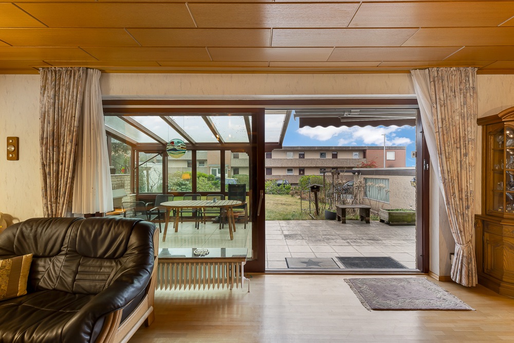 Wohnzimmer mit Blick auf Wintergarten und Terrasse im Garten.