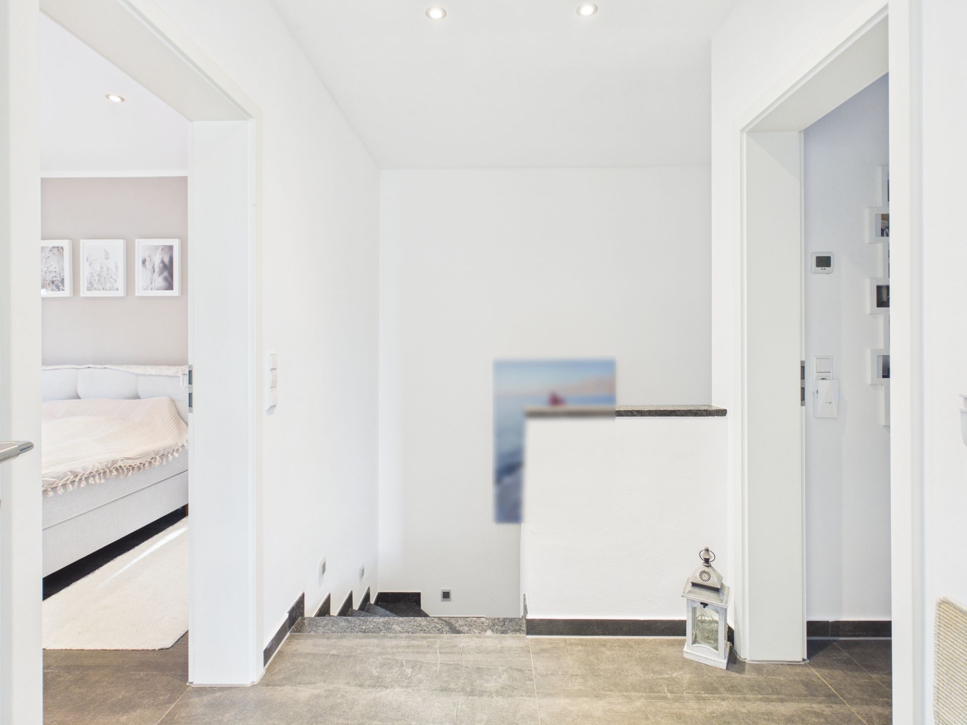 Heller Flur mit Zugang zu Schlafzimmer, Treppe und Wanddeko.