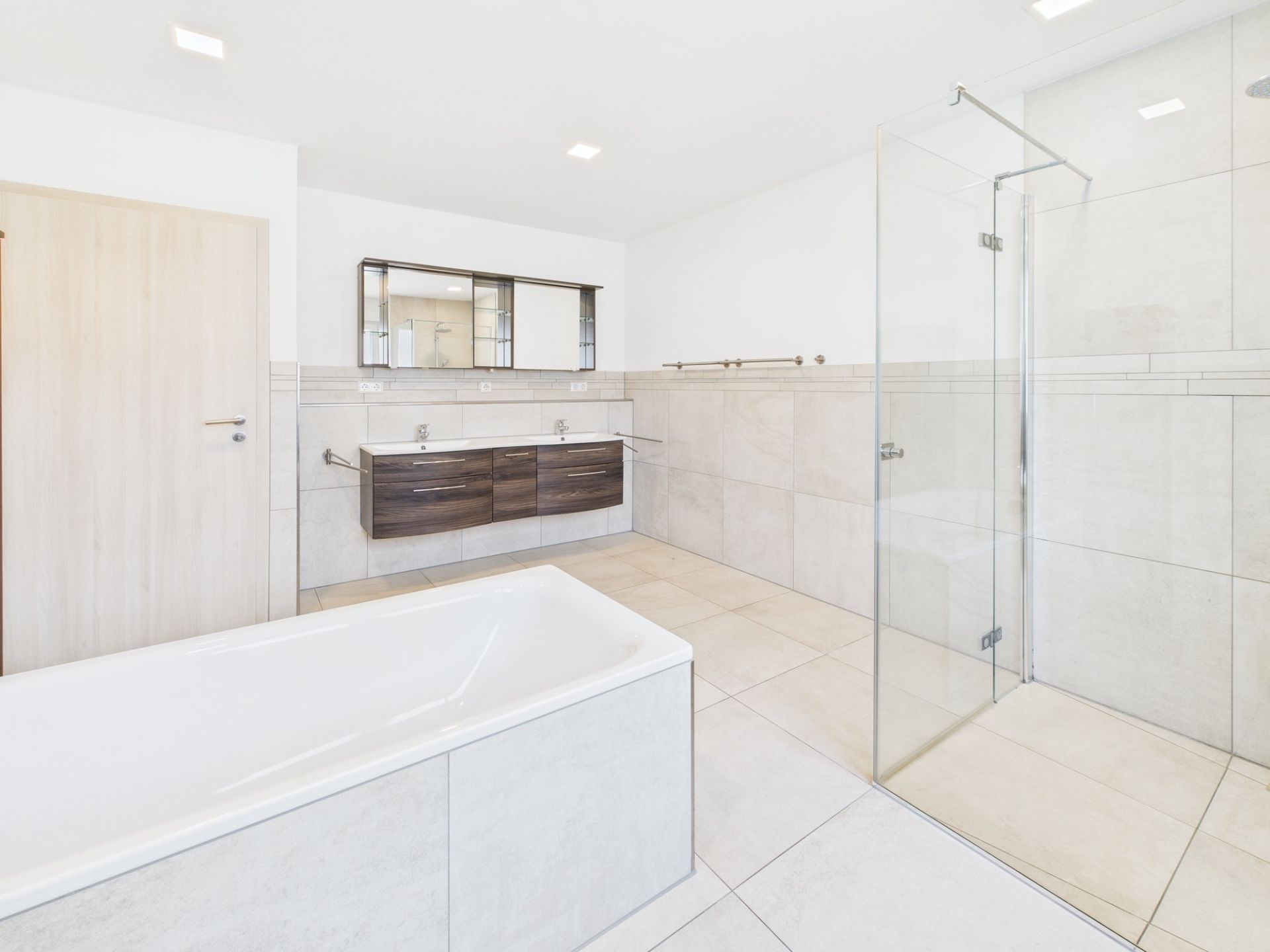 Modernes Badezimmer mit Badewanne, Doppelwaschbecken und ebenerdiger Dusche.