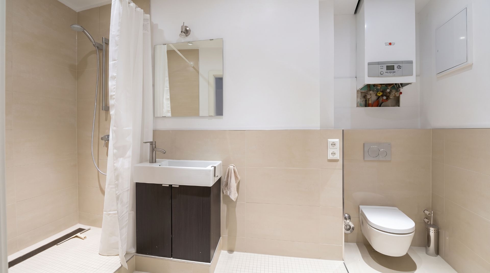 Modernes Badezimmer mit Dusche, Waschbecken, Spiegel und wandhängendem WC.