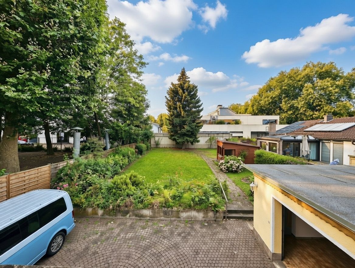 Blick auf einen Garten mit Rasenfläche, Beeten, Bäumen, einem Auto und Nebengebäuden.