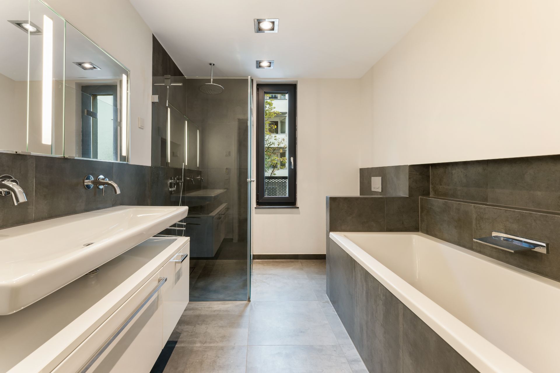 Modernes Badezimmer mit Doppellavabo, Badewanne, Dusche und Fenster.