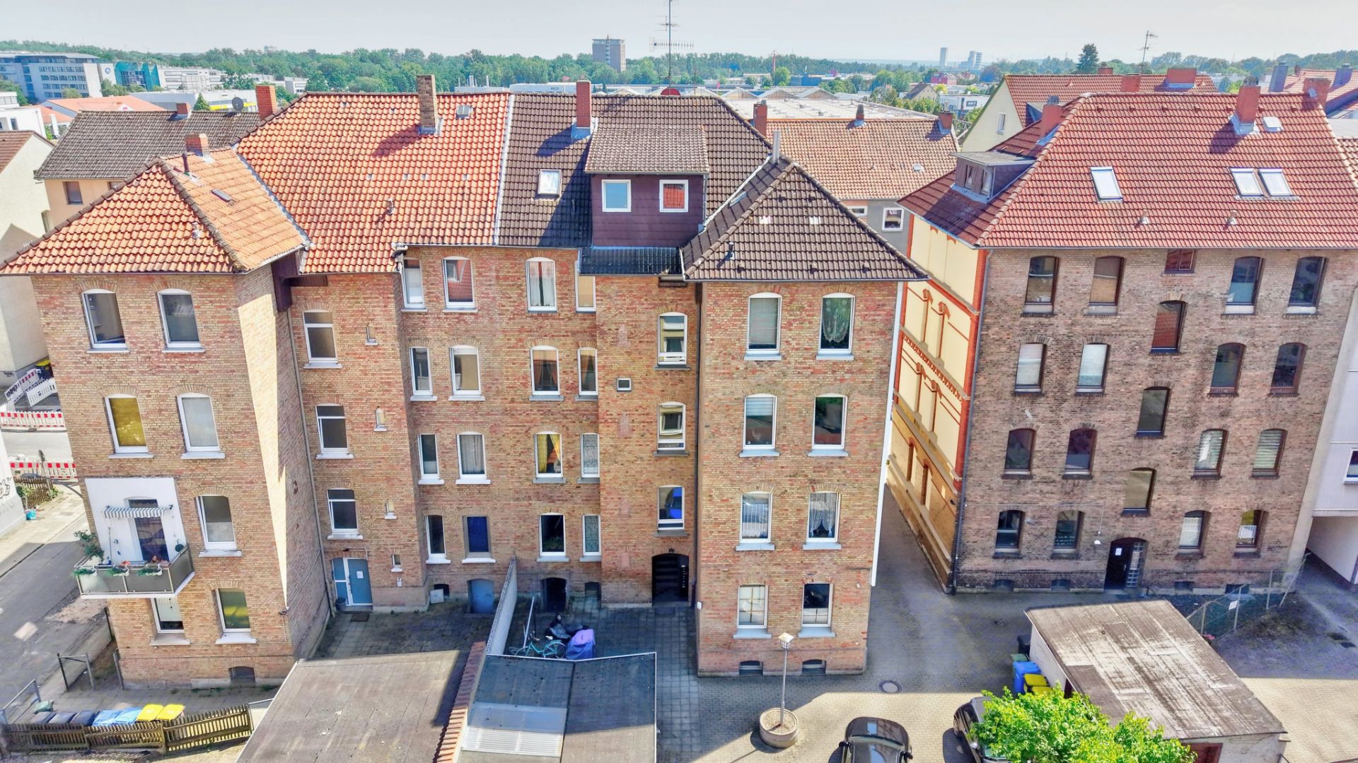 Mehrstöckige Wohnhäuser aus Backstein mit Innenhof, Blick von oben.