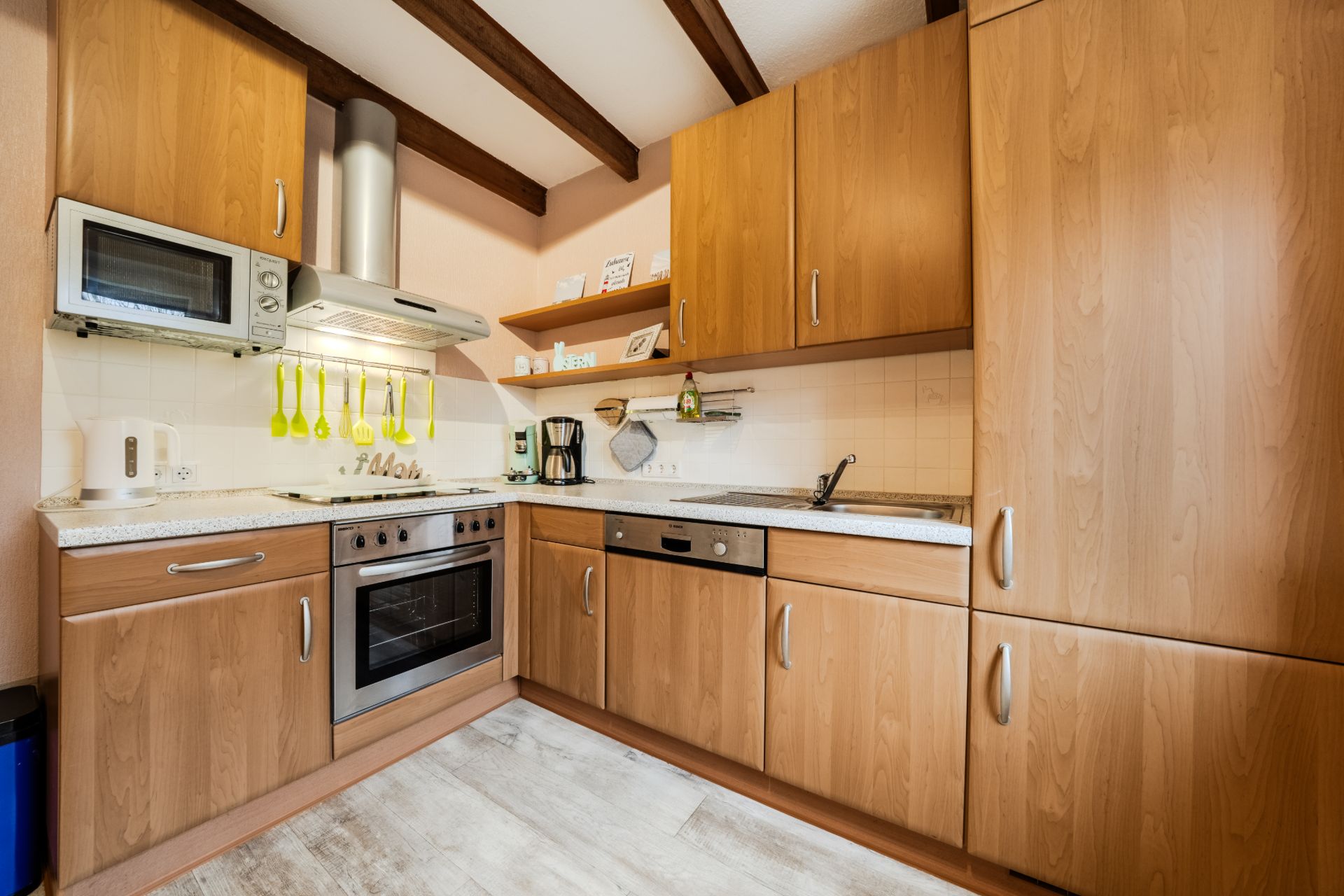 Moderne Einbauküche mit Holzfronten, Backofen, Spüle, Ober- und Unterschränken.