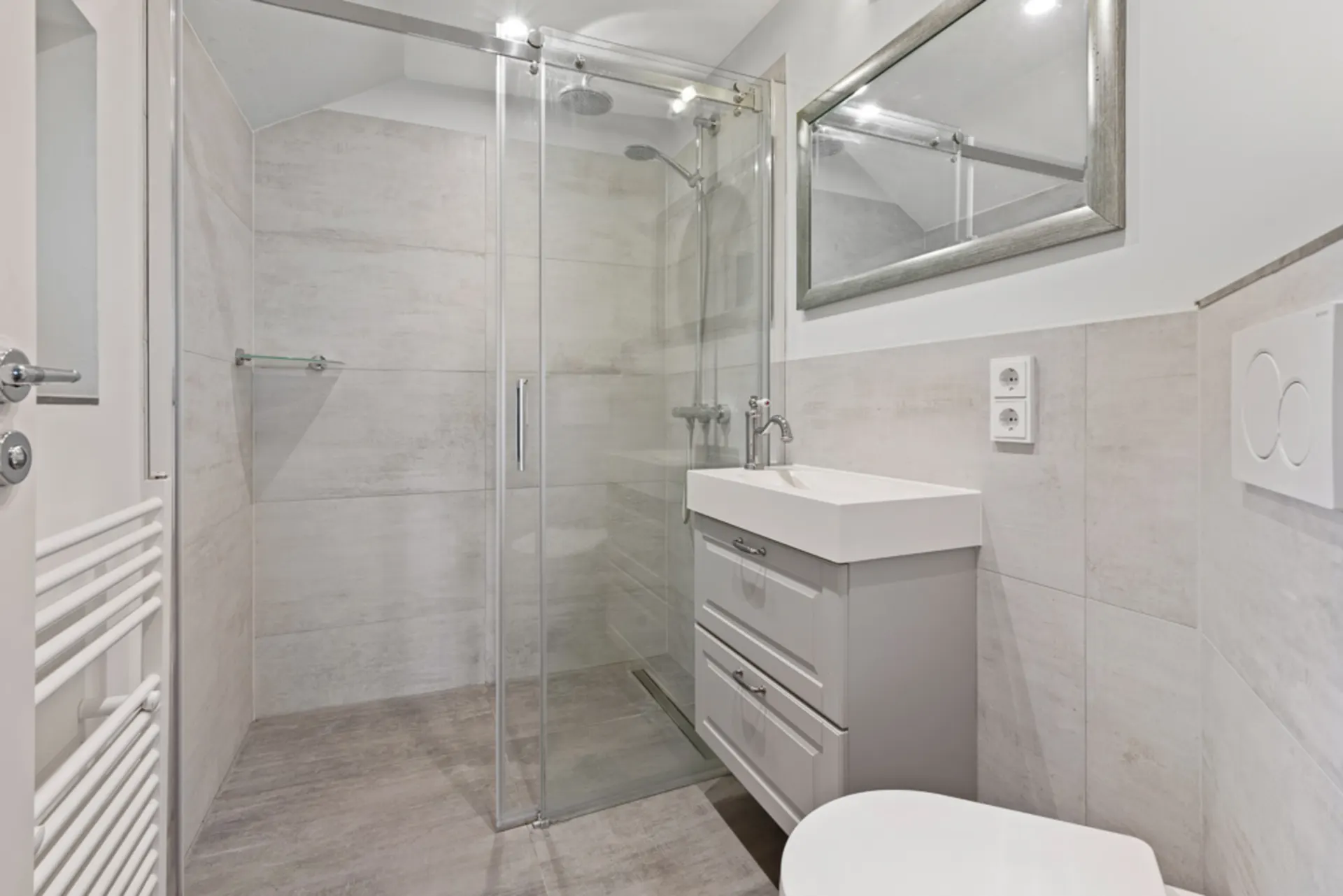 Modernes Badezimmer mit großer Dusche, Waschbecken mit Unterschrank und Spiegel.