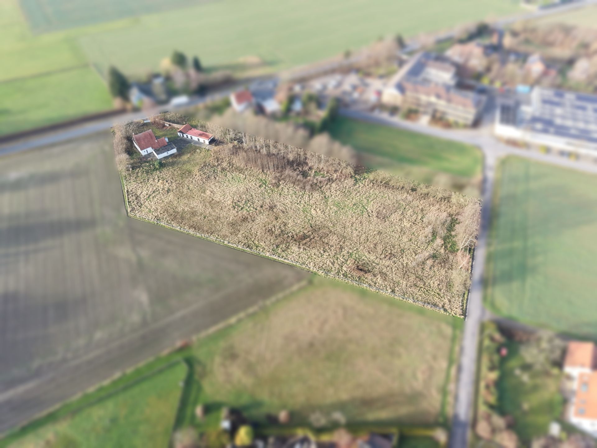 Luftaufnahme eines rechteckigen Grundstücks mit Wiese und Haus, von Feldern umgeben.