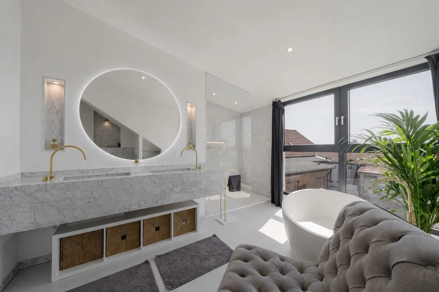 Modernes Badezimmer mit großem Spiegel, freistehender Badewanne und großen Fenstern.