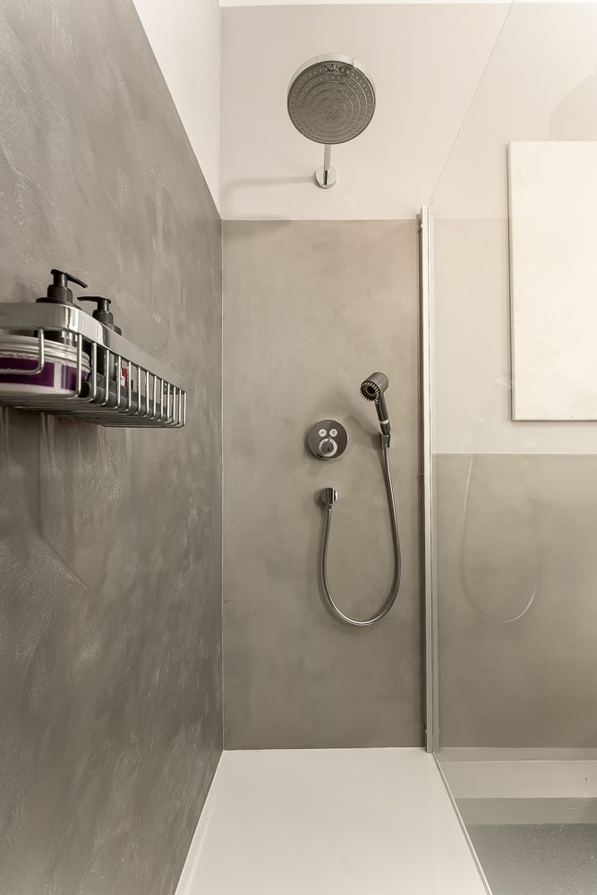 Moderne, begehbare Dusche mit Regendusche, Handbrause und Duschgelspender an der Wand.