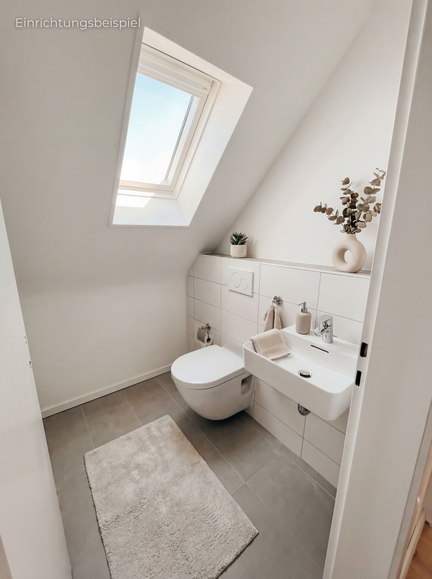 Helles Bad mit Wandtoilette, kleinem Waschbecken, Teppich und Dachfenster.