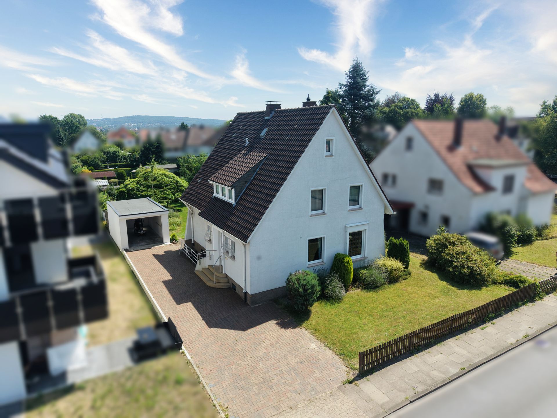 Freistehendes Einfamilienhaus mit Garten, Einfahrt und Garage in einer Wohnsiedlung.