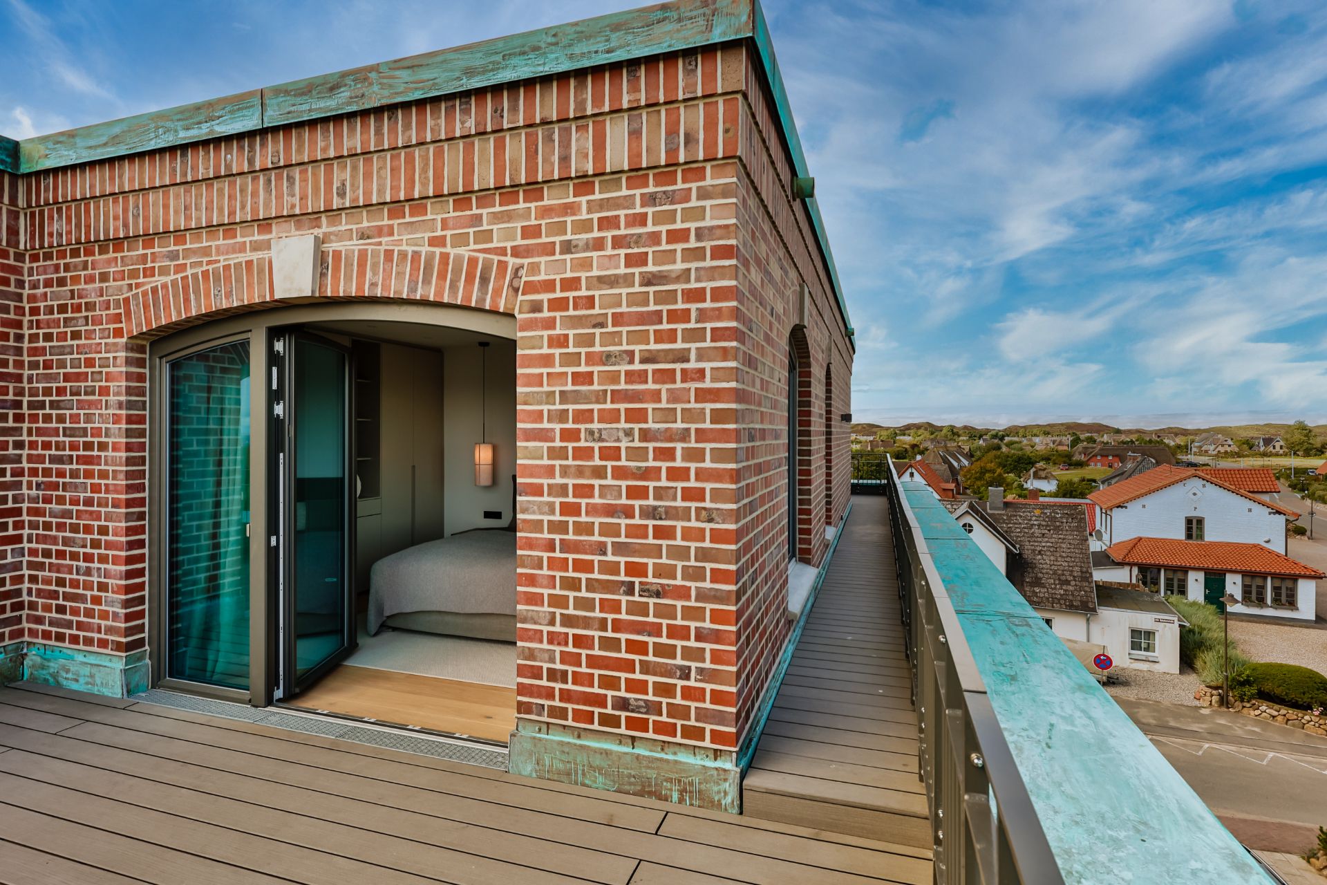 Backsteingebäude mit offenem Schlafzimmer und Zugang zu einer Dachterrasse.