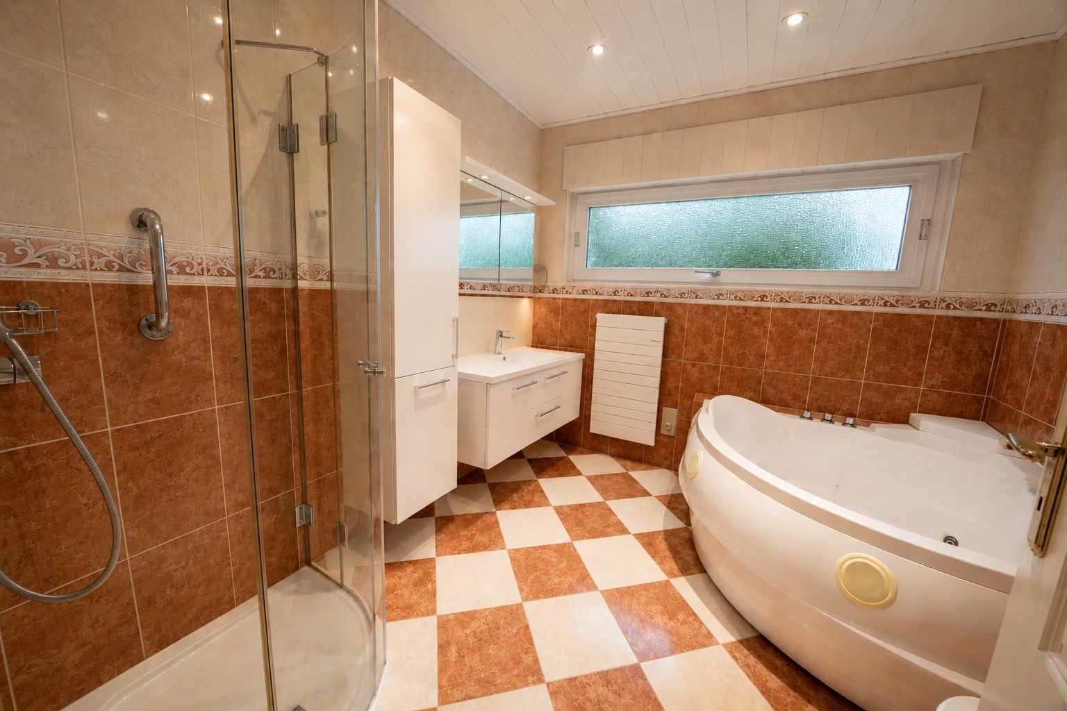Modernes Badezimmer mit Dusche, Eckbadewanne, Waschbecken und großem Fenster.