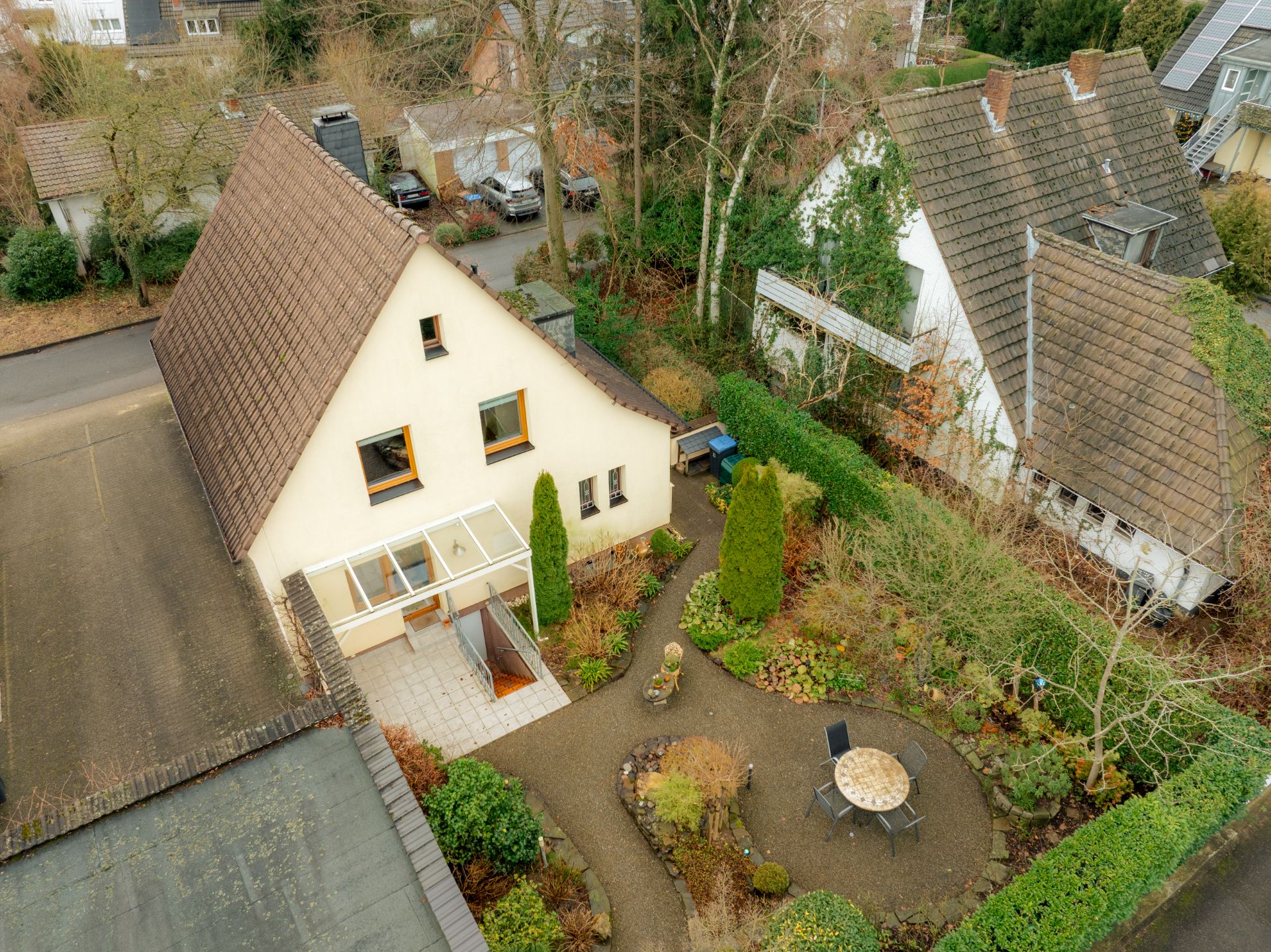 Luftaufnahme eines Einfamilienhauses mit Garten, Terrasse und Sitzbereich im Hinterhof.