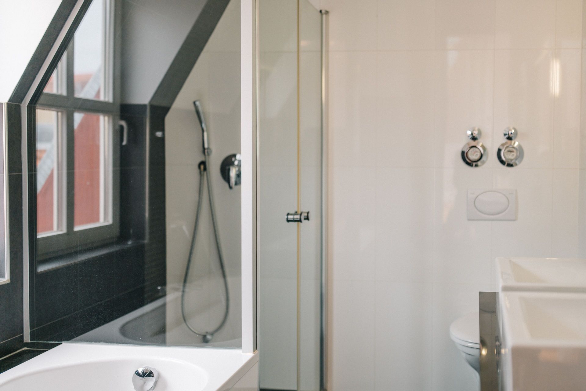Modernes Badezimmer mit Badewanne, Dusche, Fenster und zwei Waschbecken.