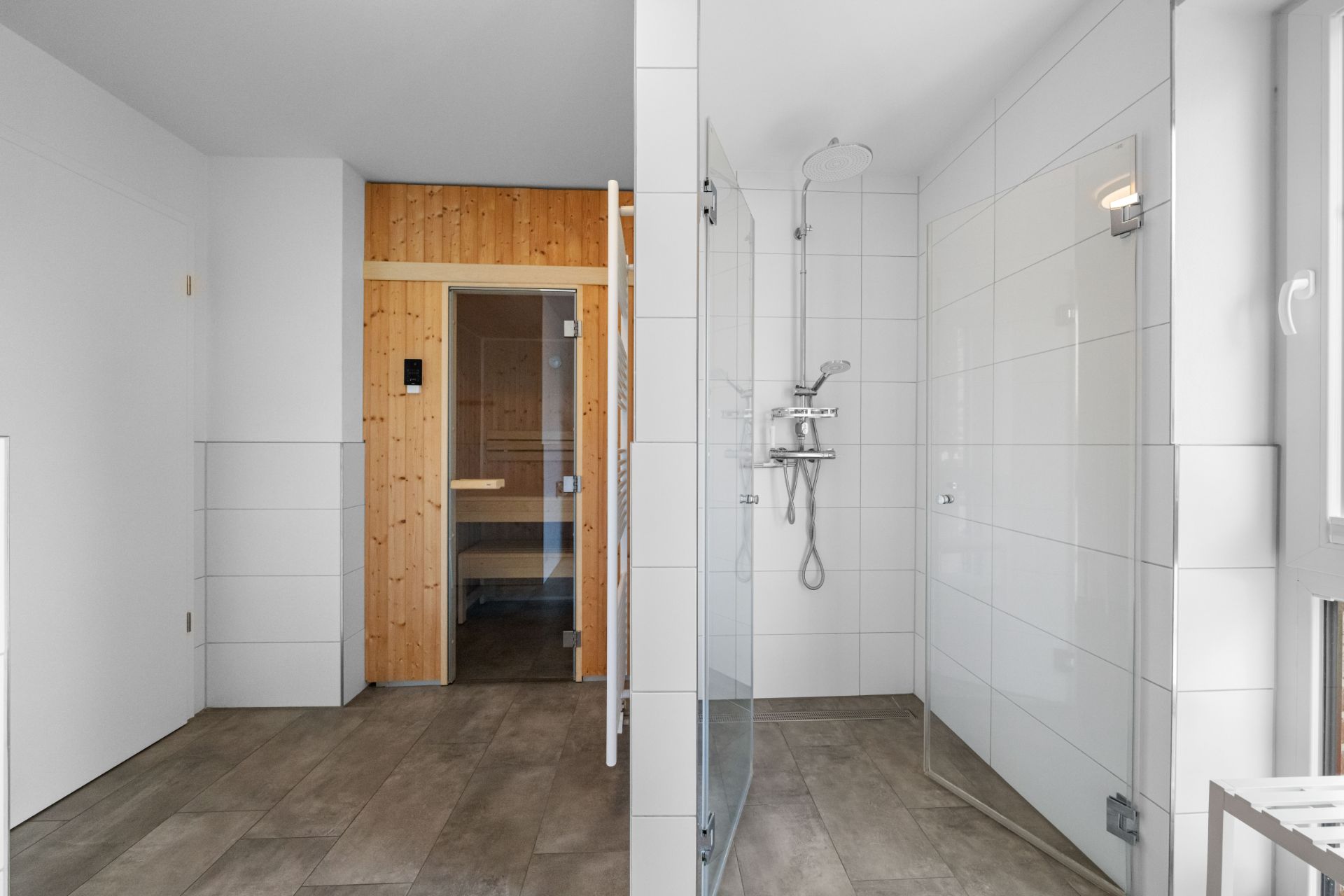 Modernes Badezimmer mit Dusche und einer Sauna mit Holzwänden.