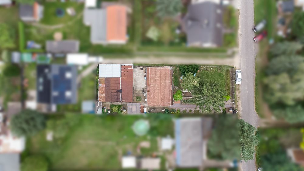 Luftaufnahme eines Wohnhauses mit Garten und angrenzender Straße.