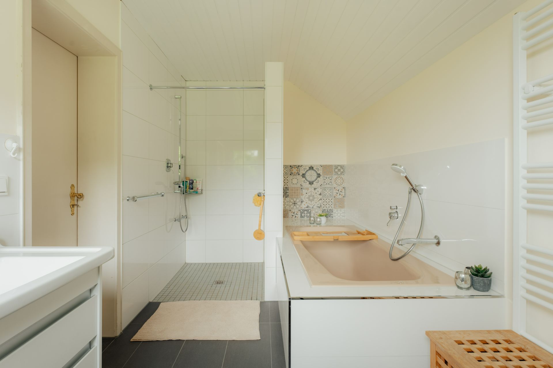 Modernes Badezimmer mit offener Dusche, Badewanne und weißen Fliesen.
