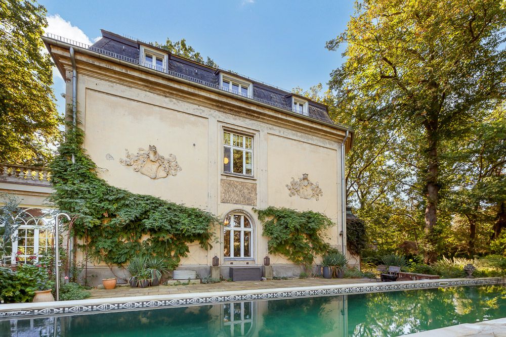 Großes Wohnhaus mit Kletterpflanzen an der Fassade und Schwimmbecken im Garten.
