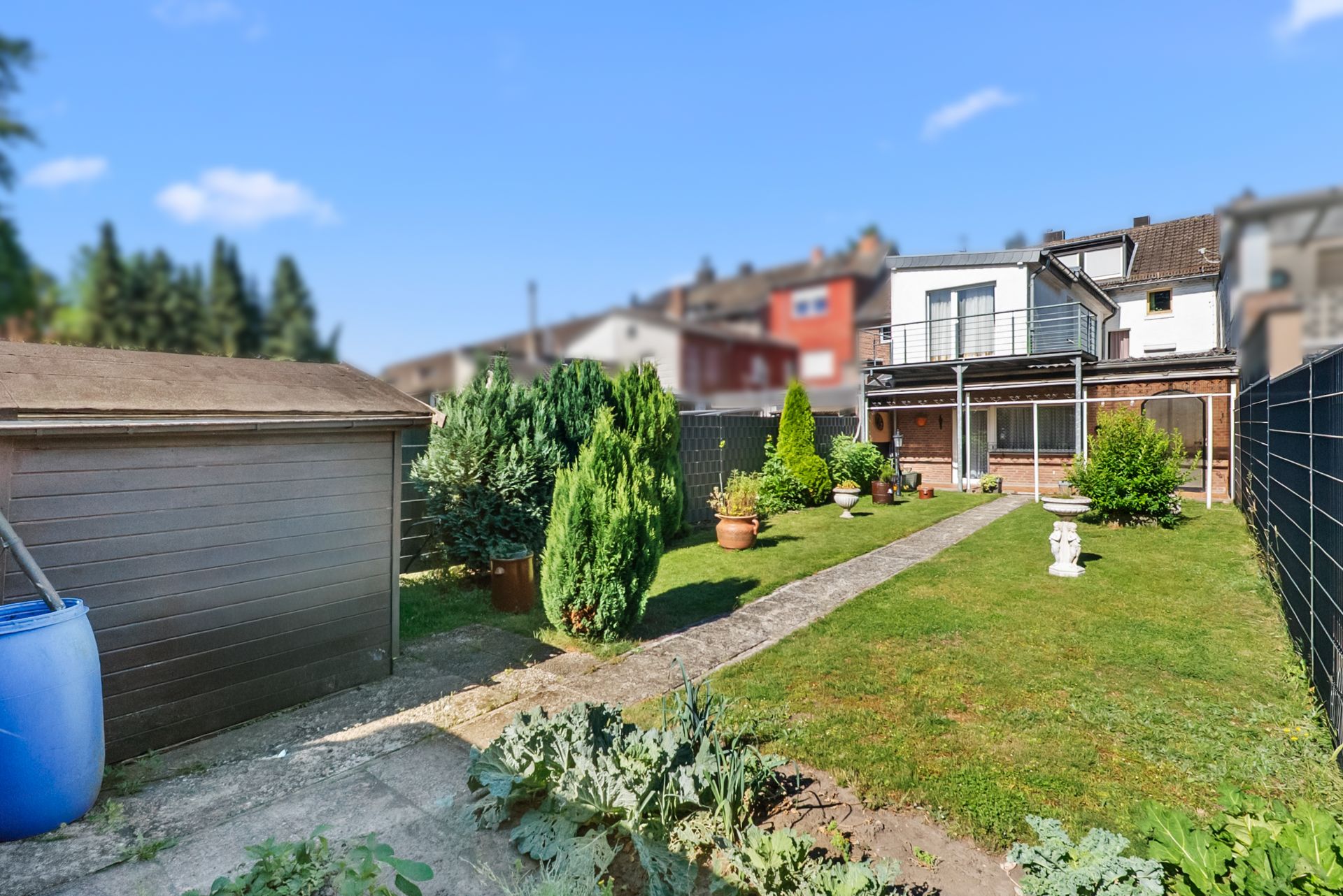 Gepflegter Garten mit Rasen, Gehweg, Gartenhaus, Pflanzen und Wohnhaus im Hintergrund.