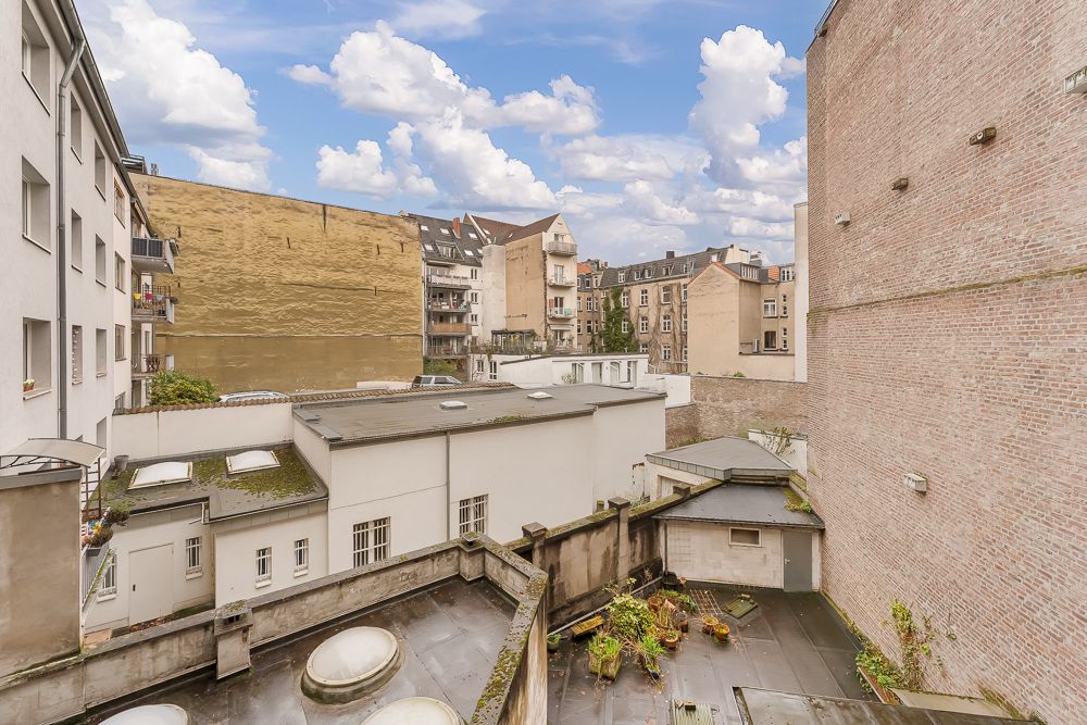 Blick auf einen Innenhof mit mehreren Wohngebäuden und bepflanzten Dachflächen.