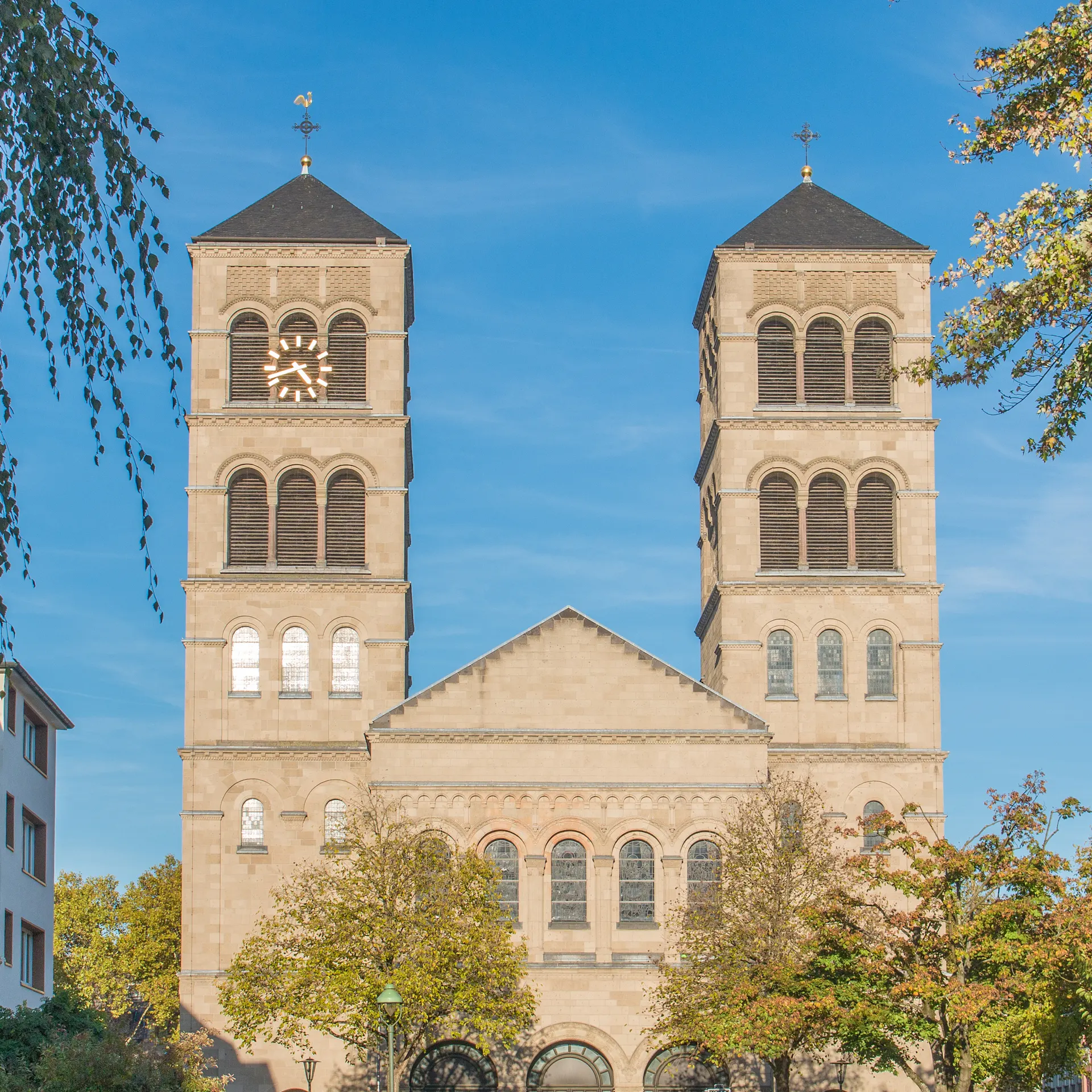 Historisches Gebäude mit Uhrturm und Reiterstatue auf einem offenen Platz, umgeben von Wohnhäusern.