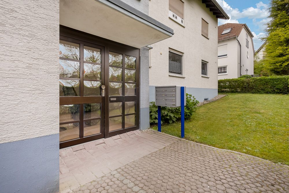 Eingangstür eines Wohnhauses mit Glasflächen und Briefkastenanlage daneben.