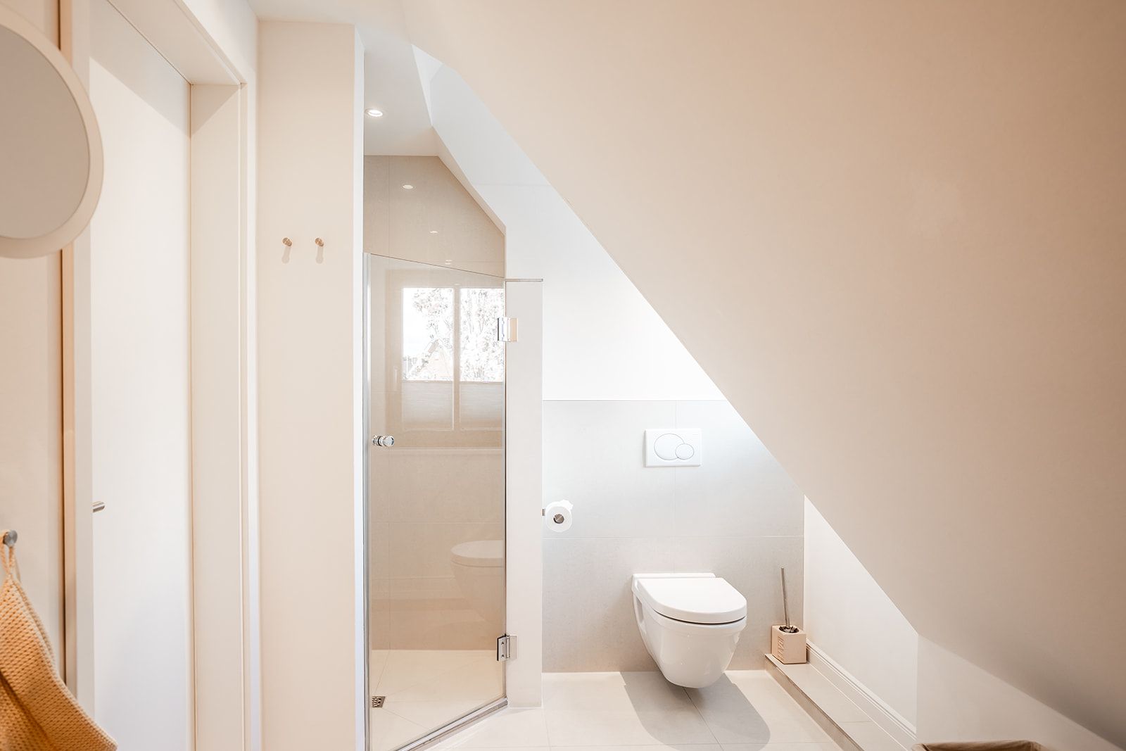 Modernes Badezimmer mit Dusche und WC unter einer Dachschräge.